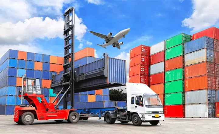 camión azul de operaciones logísticas coordinadas por un freight forwarder con servicios de carga aérea y marítima en un patio de contenedores.