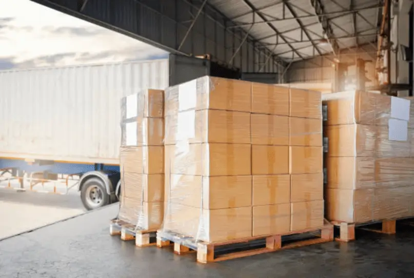 Palets con cajas listas para ser cargadas en un contenedor en un almacén logístico, representando el proceso de envío y almacenamiento en el contexto de qué es carga consolidada.