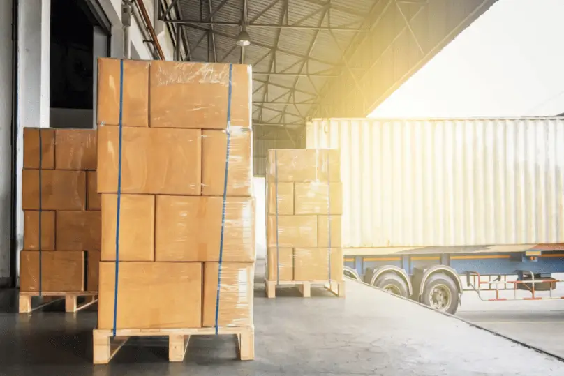 Pallets de cartón flejados y organizados para ser cargados en un contenedor, como parte del proceso previo al transporte aéreo de mercancías.