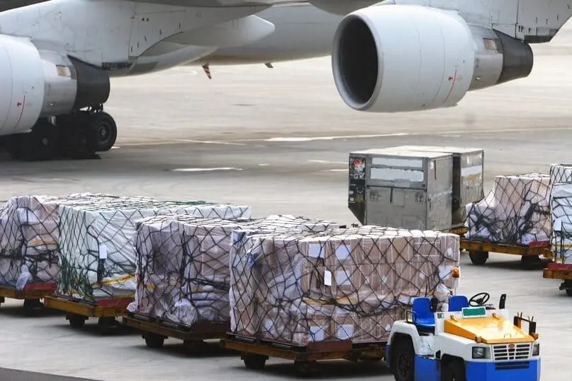 Múltiples pallets listos para ser embarcados en un avión, ilustrando la logística involucrada en el transporte aéreo de mercancías.
