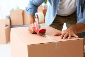 Caja siendo sellada cuidadosamente para embalar mercancías frágiles